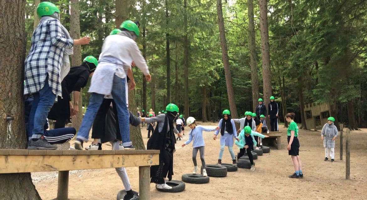 Young people taking part in an outdoor team challenge
